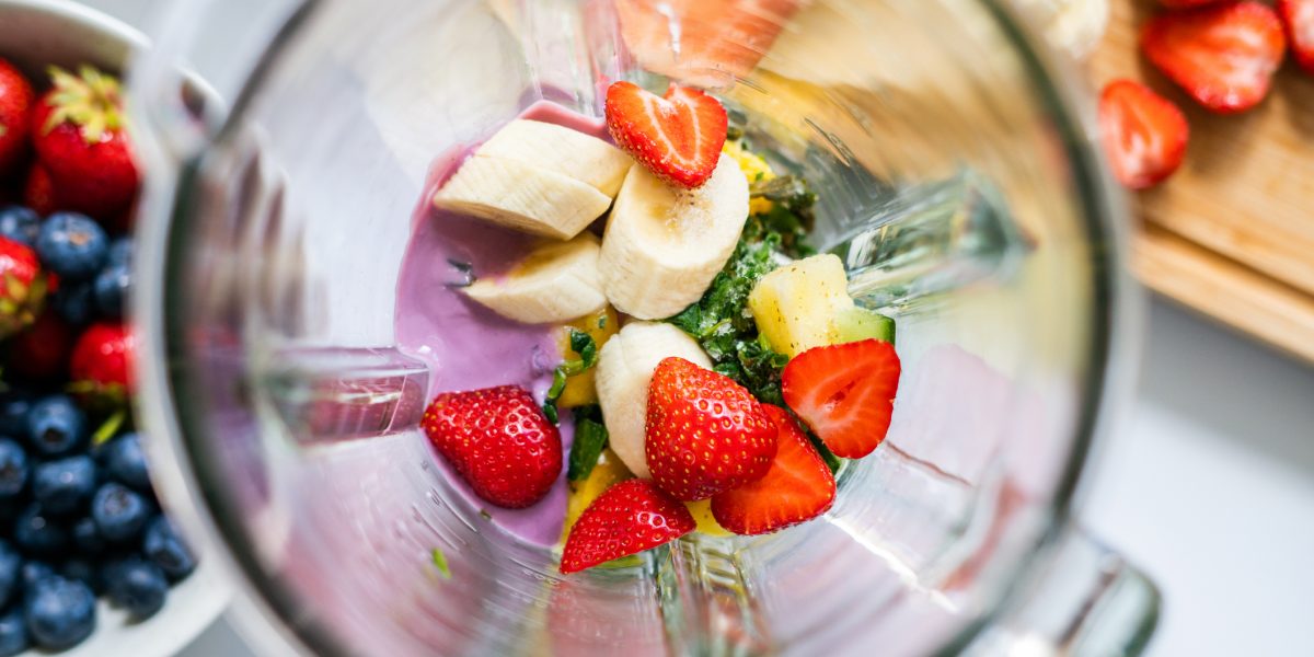 Top view of cut fruits and berries in a blender